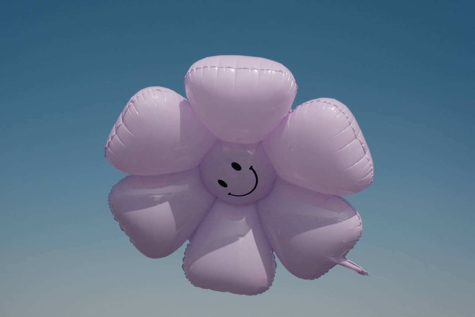 a balloon shaped like a flower with a smiley face drawn on it